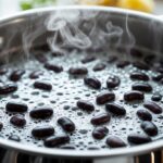 Feijão preto fervendo com espuma na superfície da água em uma panela.